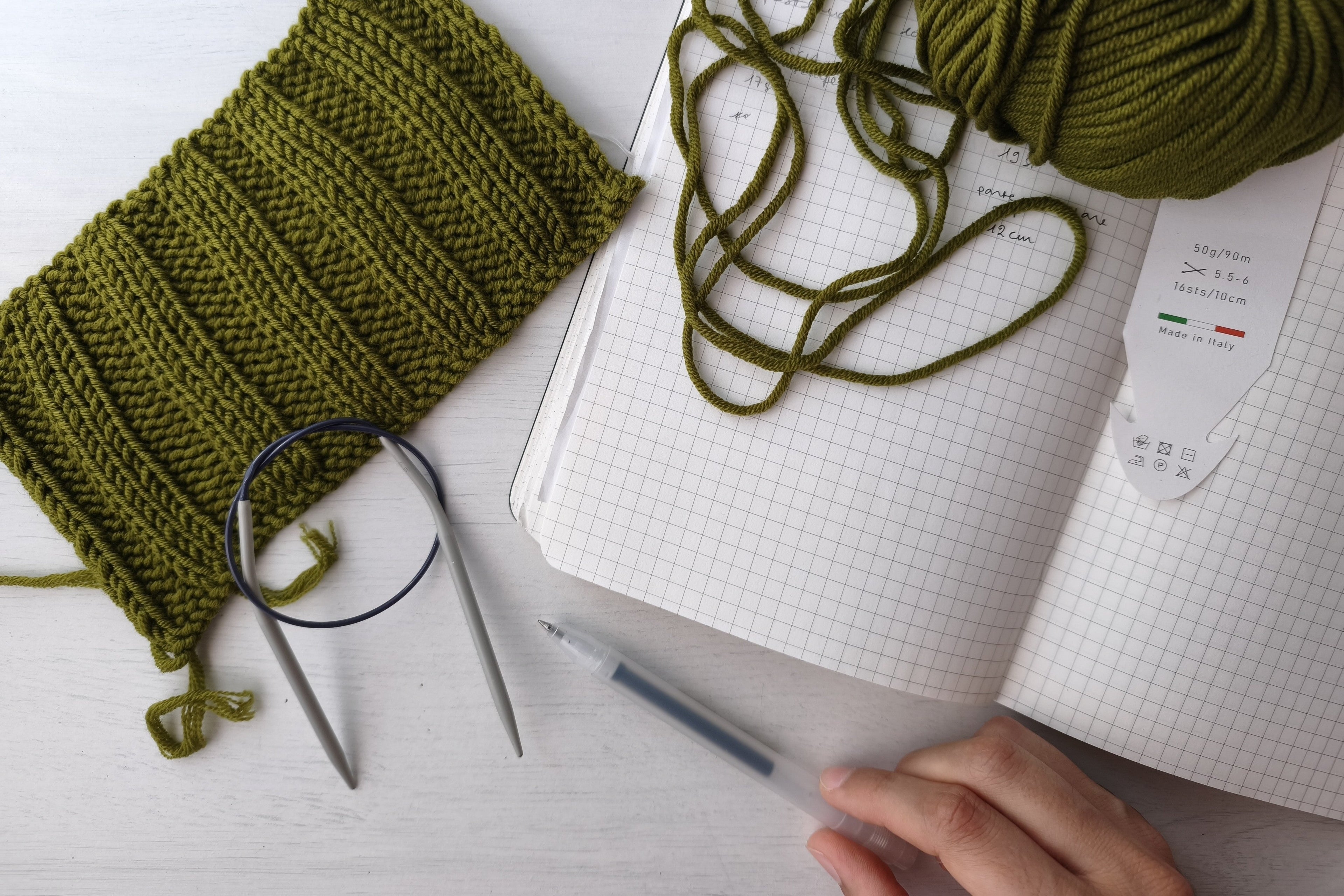 Quaderno, filati e strumenti creativi su un tavolo, simbolo della creatività come pratica quotidiana