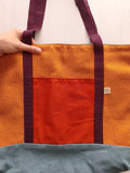 Borsa ocra con cinghie bordeaux, base della borsa grigio azzurro e tasca esterna arancione scuro