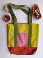 Borsa shopper verde acido con tasca esterna rosa, base arancione e cinghie verdi