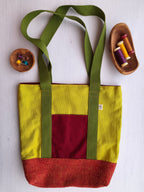 Borsa shopper verde acido con tasca esterna rossa, base rosso-arancio e cinghie verdi