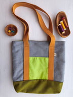 Borsa shopper grigia con tasca esterna verde acido, base verde e cinghie gialle