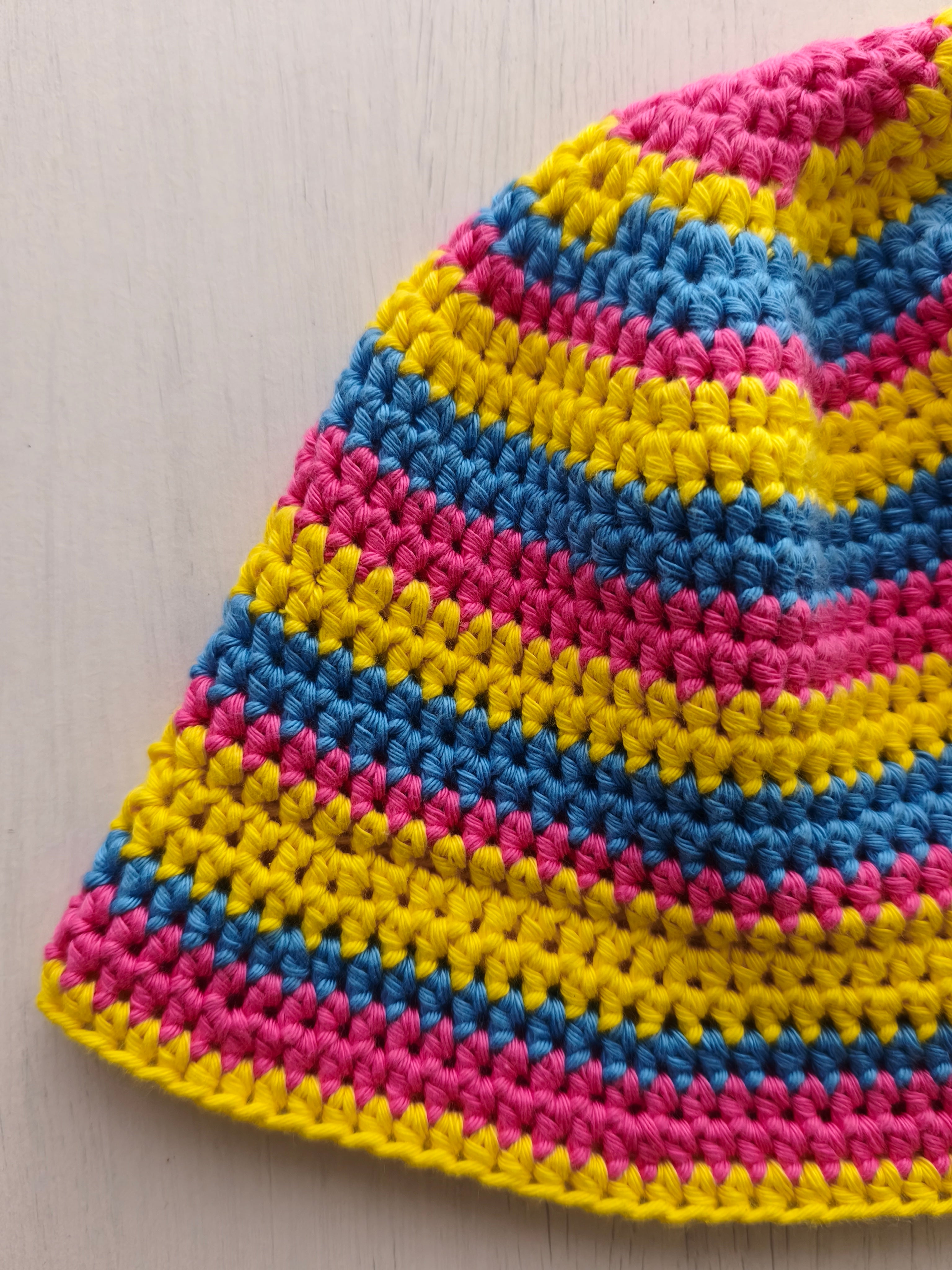 Dettaglio bucket hat all'uncinetto giallo, rosa e blu