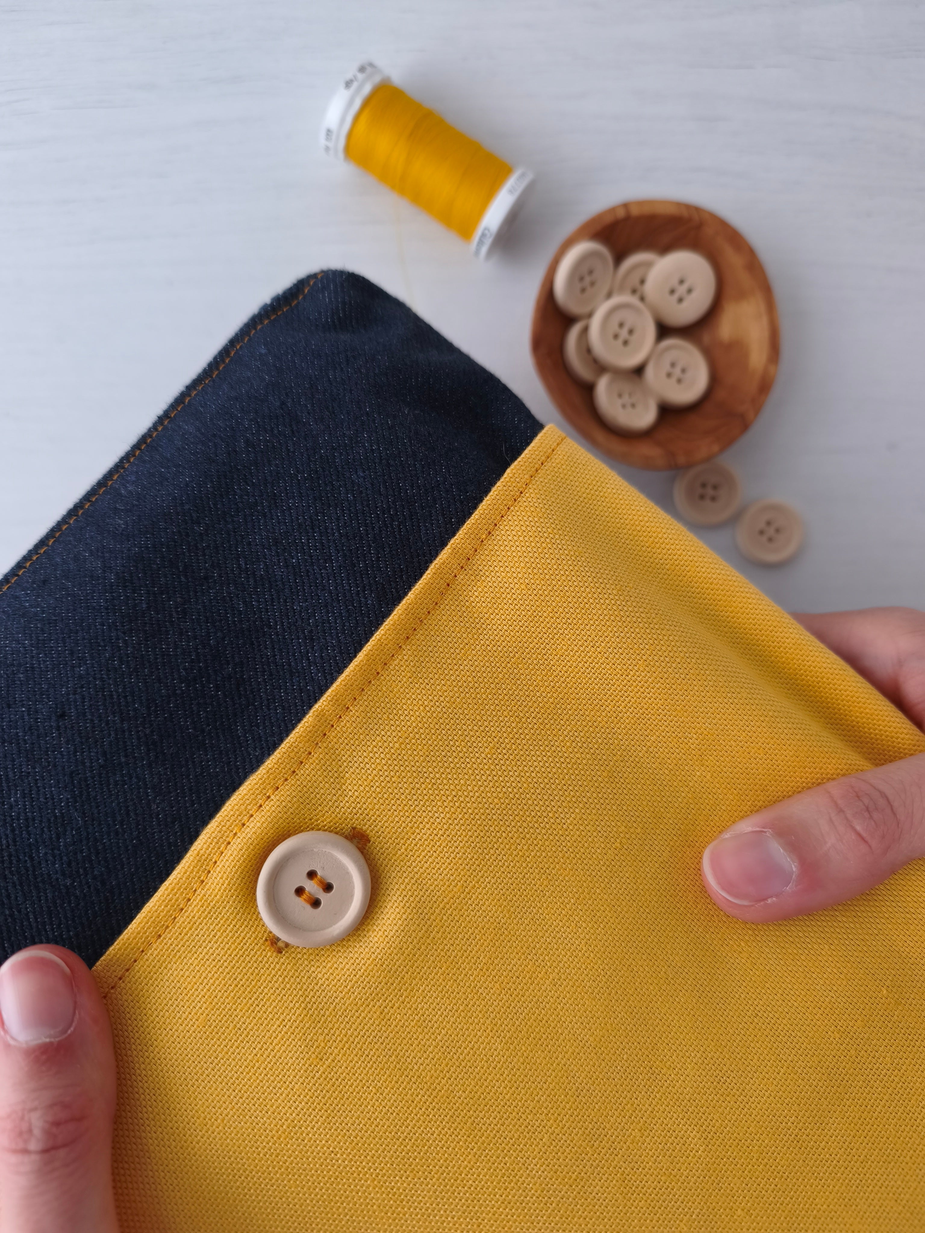 dettaglio della tasca frontale con bottone in legno del save your books