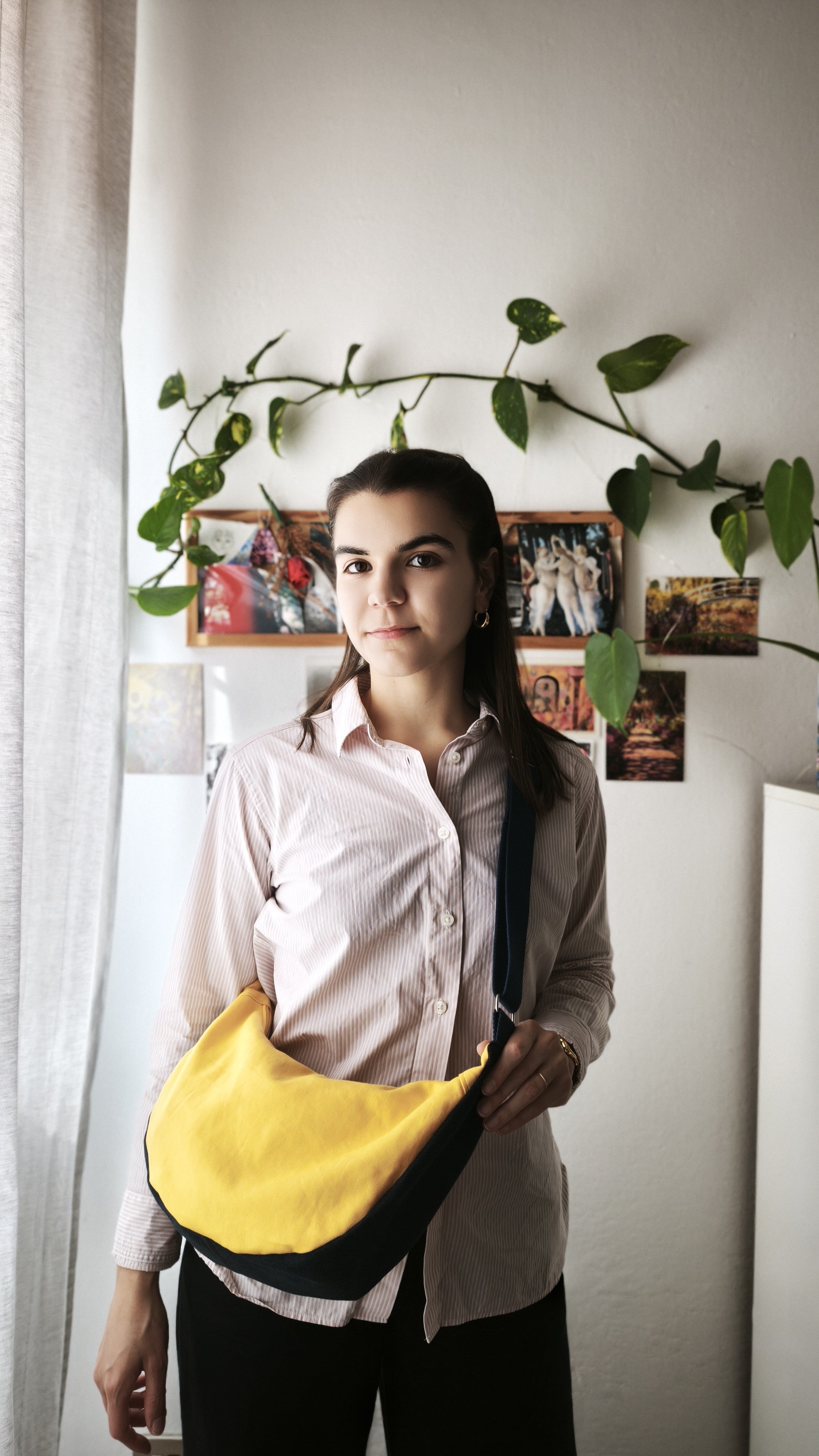 Moonbag indossata, vengono inseriti quaderno, borraccia, portafoglio e pochette